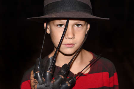 Boy in a suit with a terrible glove with knives.