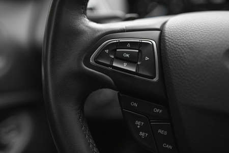 Control buttons on a leather steering wheel of a car.の写真素材