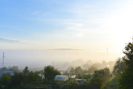 Gardens in the village in the morning in the fog.の写真素材