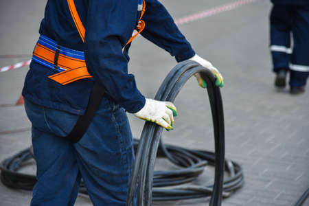 Workers dismantle the telecommunication cable in the well.の写真素材