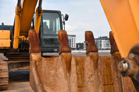 Yellow excavator bucket on the street.