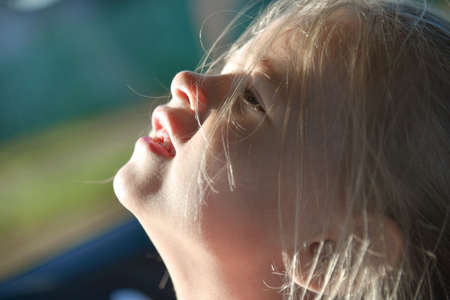 The child laughs in the car, face, close-up.の写真素材