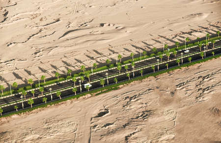 Long highway in the desert among mountains and sands, top view.の写真素材