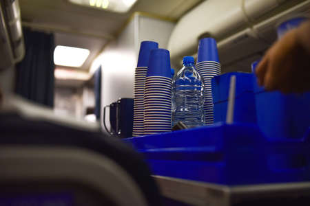 Stewardess on a plane gives drinking water to a passenger.の写真素材