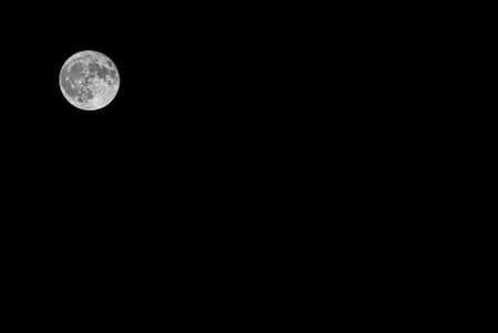 Full moon in the black sky at night.