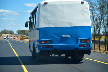 Old bus rides on a new asphalt road.の写真素材