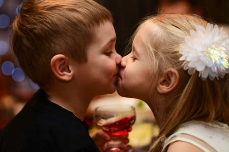 Children boy with girl kiss on holiday.