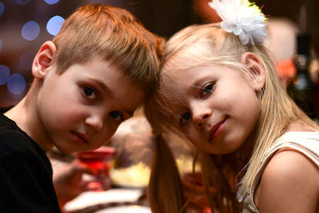 Children boy with girl drink together and cuddle on holiday.