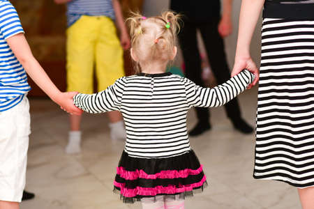 People hold baby hands at party, rear view.の写真素材