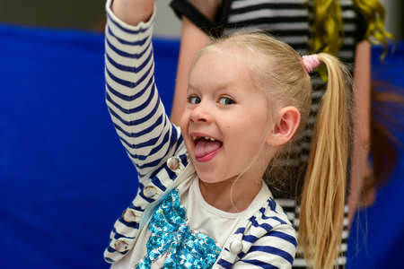 Child girl shows tongue at a party.