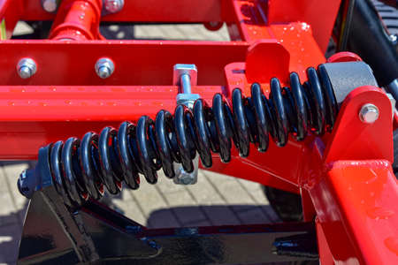 Large red shock absorber on an industrial vehicle.