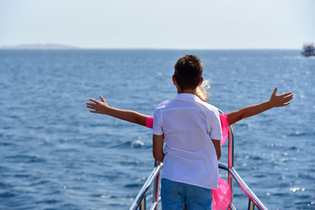 Teen boy hugs teen girl on the bow of a yacht in the sea.の写真素材