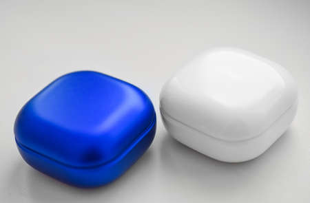 Two colored cases for wireless headphones on a white background.