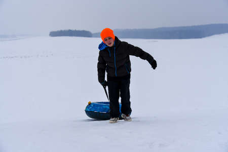 Teen Pulls Tubing Down A Snow Slide.