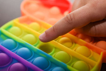 Child finger presses the ball on the color