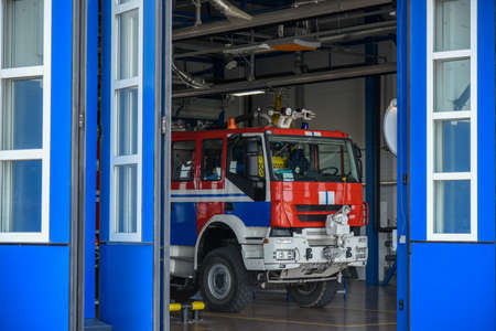 the fire truck is in the garage box of the fire station.
