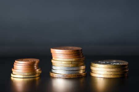 Tower of metal coins on black background.の写真素材