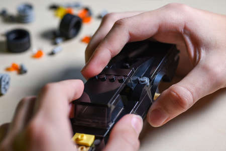 The hands of a teenager assemble a constructor from parts.の写真素材