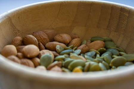 Mix with almonds, and pumpkin seeds in a wooden bowlの写真素材