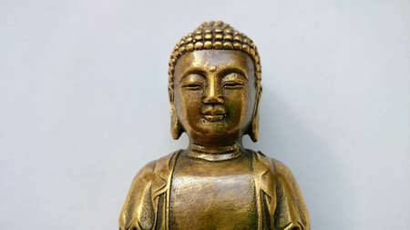 Golden statuette of a seated Buddha Shakyamuniの写真素材
