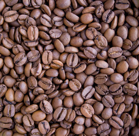 Roasted brown coffee beans close up background macroの写真素材
