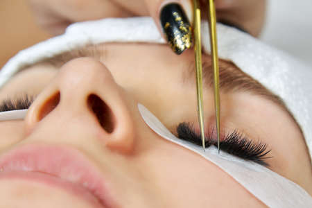 Close-up of a cosmetic procedure for gluing eyelashes by a cosmetologist. View registration procedureの写真素材