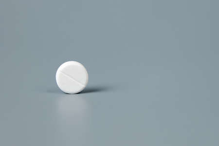 Round white pill on a gray background. High quality photoの写真素材
