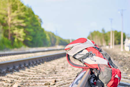 Red backpack near the railway on the background of a pine forest. Travel conceptの写真素材