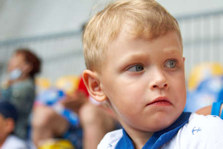 Dissatisfied blue eyed boy on the performance is looking away