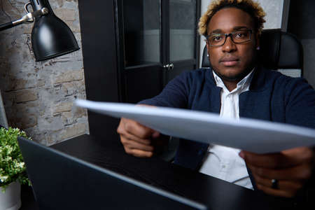 Close up serious black businessman hands over the documents prepared during. A confident African...