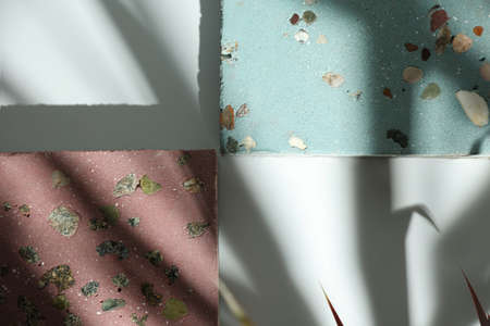 Close up sample of decorative concrete paving slabs of pink and blue color with marble chips inside....