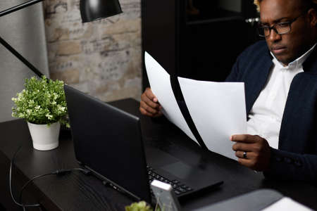 A male businessman works with business reports and financial charts. Registration of documents late...