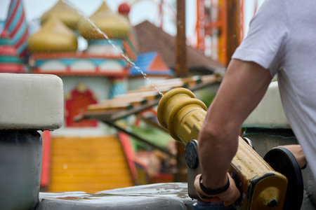 Adults with water cannons have fun at a summer holiday on a hot day. Man has fun with water in the open air, shoots from a toy cannon with a water jetの写真素材