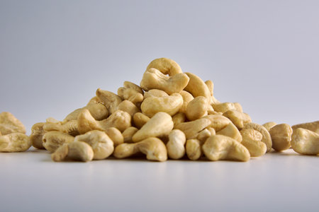 Raw cashew nuts on a gray background are laid out with a slide to get an appetizing photo. Advertising of healthy snack foods for vegetariansの写真素材