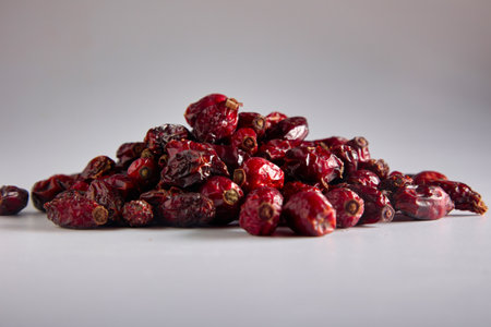 Close-up of a bunch of delicious bright red rosehips on a gray background. Useful vitamin superfood from rose hips laid out for photo on a gray backgroundの写真素材
