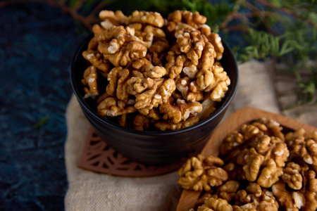 Top view of a delicious walnut in a beautiful interior. A lot of peeled walnuts in a ceramic black...
