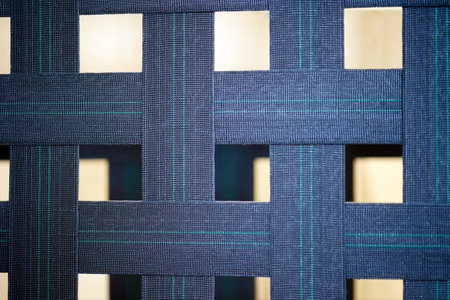 Wide strips of thick blue fabric are intertwined with each other. Grid background of blue lines....