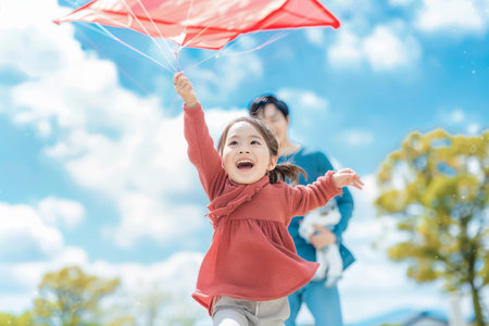 Joyful Asian Girl Flying Kite A Heartwarming Moment with Dad in Public Park (Family, Childhood)の素材