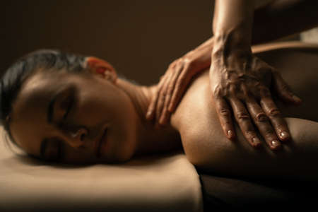 The beautiful girl has massage. Authentic image of luxury spa treatment. Warm colors, charming light.の写真素材