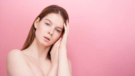 Close-up shot of young woman on pink background.の写真素材