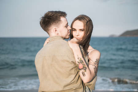 Portrait of lovely couple cuddling near the sea. Ocean background. honeymoon. millennial. Just married. High quality photoの写真素材