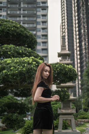 Portrait of beautiful asian girl in black dress. Wind in her hair. Looking aside. Lovely Vietnamese woman. High qualityの写真素材