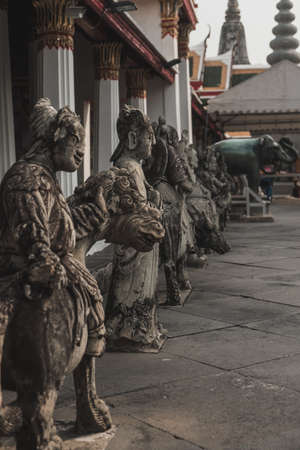 Stone statues stand near a pagoda in Bangkok in Thailand. High quality photoの写真素材