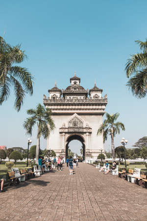 Ancient beautiful arch in the park in Laos. Walking street with palms. Architecture in Laos. Park in Asiaの写真素材