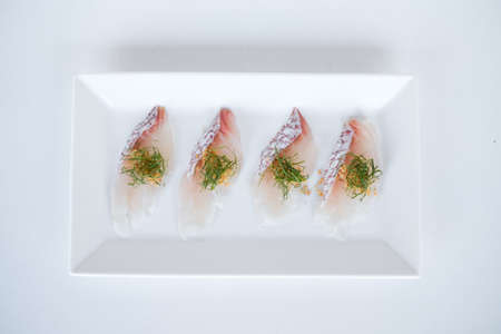 Sea bass sashimi on white plate on white background. Isolated on white. Japanese restaurant. Japanese traditional food. Raw fish.の写真素材