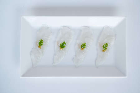 Sashimi on white plate on white background. Isolated on white. Japanese restaurant. Japanese traditional food. Raw white fish. Photo for the menuの写真素材