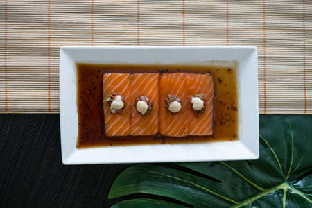 Salmon sashimi with sauce on white plate. Salmon sushi served restaurant. Japanese restaurant. Japanese traditional food. Healthy food concept. Menuの写真素材