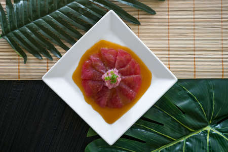 Tuna sashimi with sauce on white plate. Raw Tuna sushi served restaurant. Japanese restaurant. Japanese traditional food. Healthy food concept. Menuの写真素材