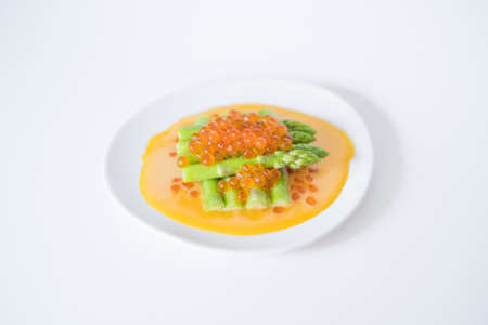 mini asparagus with sauce and red caviar on white plate, isolated on white, close up, healthy food, healthy lifestyle, picture for the menuの写真素材