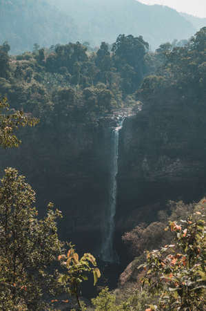 Picturesque waterfall in the mountains. Beautiful view of a high waterfall in the forest in Laos. The extraordinary nature of Asia.の写真素材